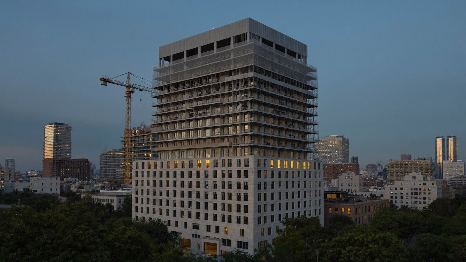 Limestone and steel mid-rise under construction near downtown San Antonio at blue hour