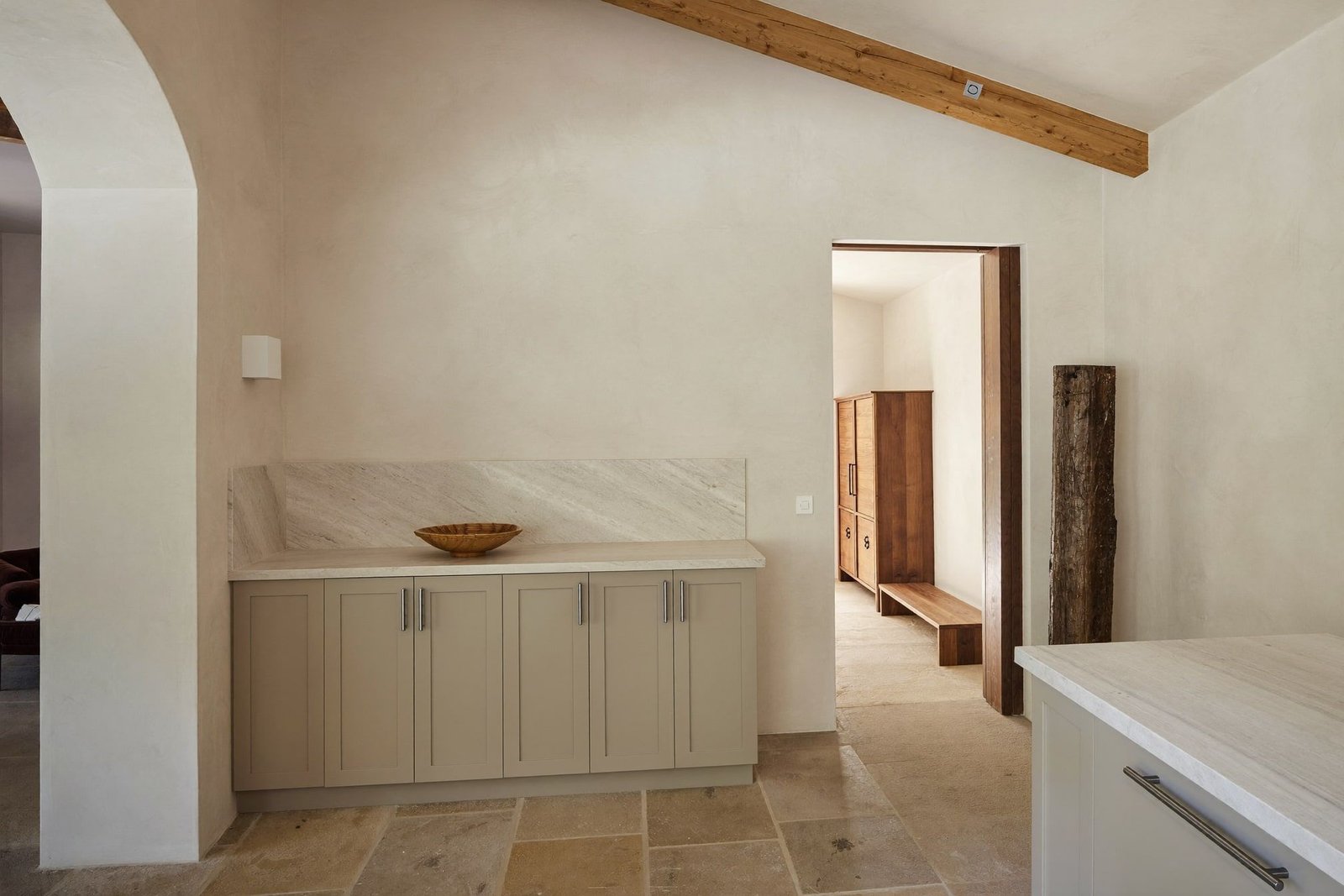 Craftsman fitting cabinetry in a nearly finished custom home with vaulted beamed ceiling and plaster walls